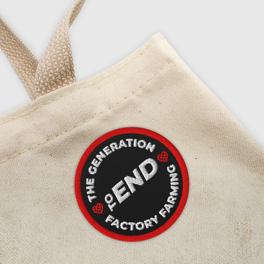 Beige tote bag with a circular patch that says The Generation to End Factory Farming.