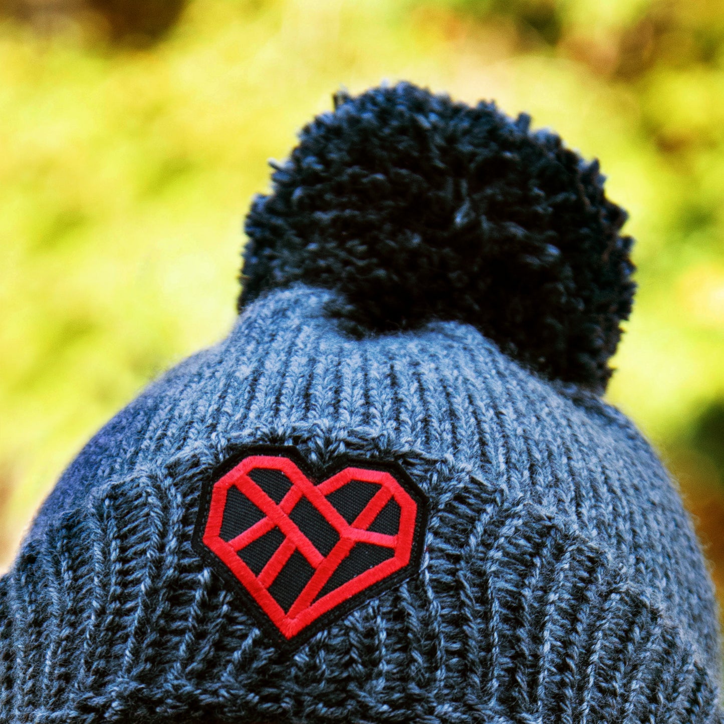 Closeup of beanie being worn outdoors against a yellow background