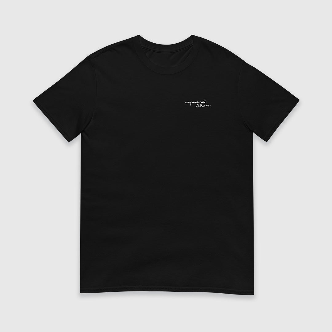 Black short sleeve t-shirt with "compassionate to the core" printed in white script on the chest on the wearer's left side.