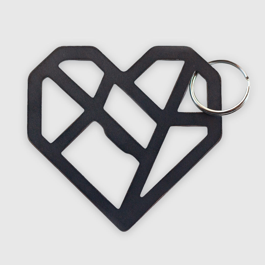 A black geometric heart-shaped keychain with an abstract, angular design. The heart is made of interconnected lines forming an open, lattice-like structure which includes within it a functional bottle opener. It's attached to a metal key ring and photographed against a white background.