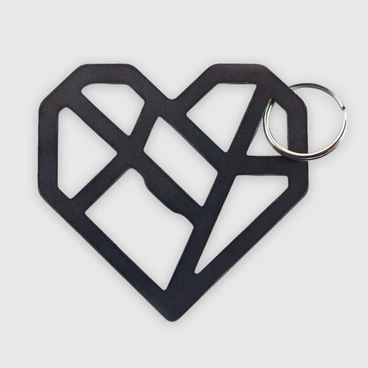 A black geometric heart-shaped keychain with an abstract, angular design. The heart is made of interconnected lines forming an open, lattice-like structure which includes within it a functional bottle opener. It's attached to a metal key ring and photographed against a white background.