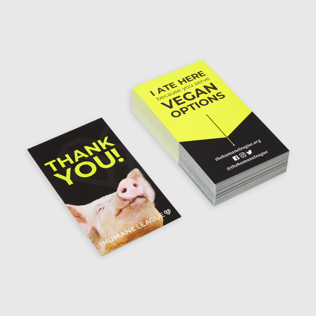 Small stack of business card sized cards. The front of the cards say, "Thank You!" with a photo of the pig. On the back of the cards it says, "I ate here because you serve vegan options".