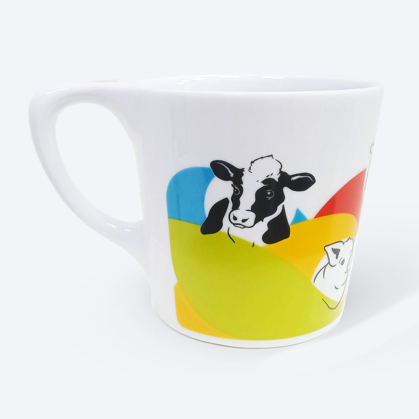 White ceramic mug with handle facing the left and a cow illustration in black facing front. A pig illustration is partly visible on the right side of the mug. There are brightly colored bands flowing under the animal heads like waves. All of the animal illustrations on the mug are in black and of the animals' heads and upper bodies.