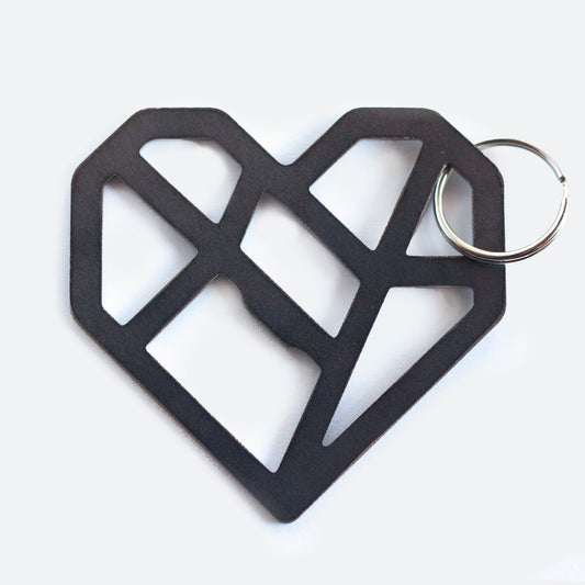 A black geometric heart-shaped keychain with an abstract, angular design. The heart is made of interconnected lines forming an open, lattice-like structure which includes within it a functional bottle opener. It's attached to a metal key ring and photographed against a white background.