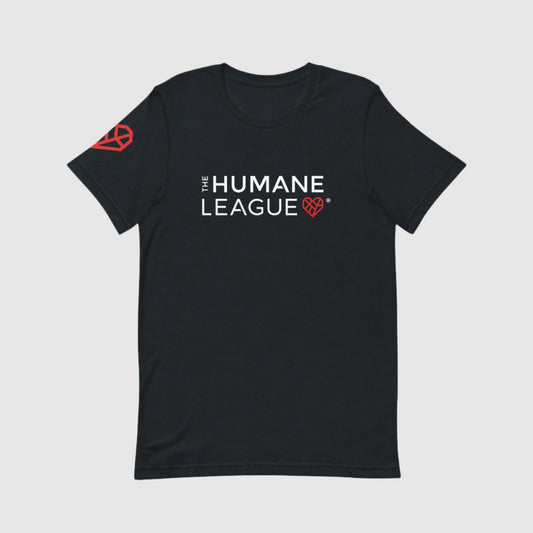 A dark gray t-shirt with "THE HUMANE LEAGUE" printed in white, using an all-caps font across the chest. Next to the text is a red geometric heart icon. The shirt also features the same heart icon on the wearer's right sleeve. 