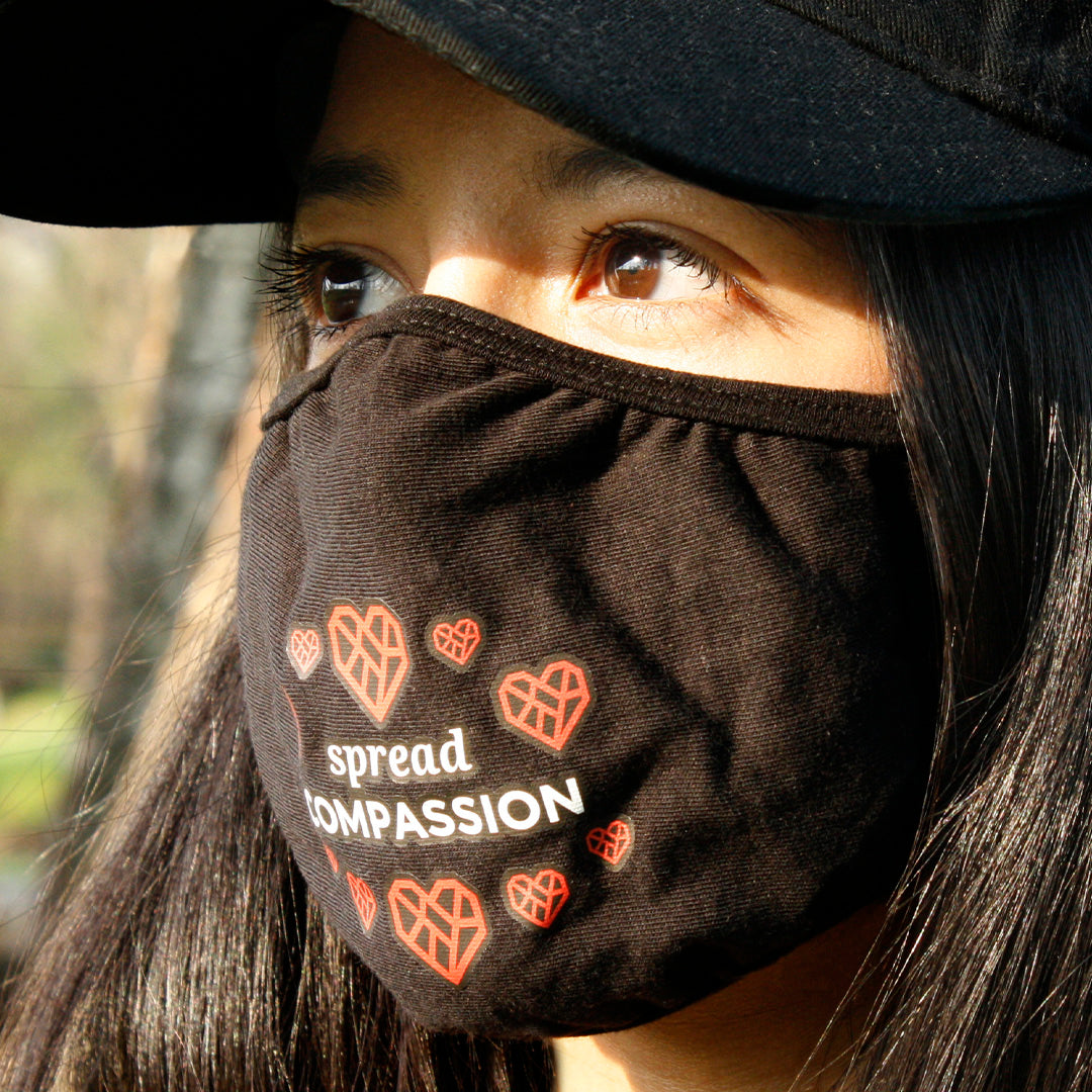 Woman with dark hair wearing the mask and a black baseball cap.