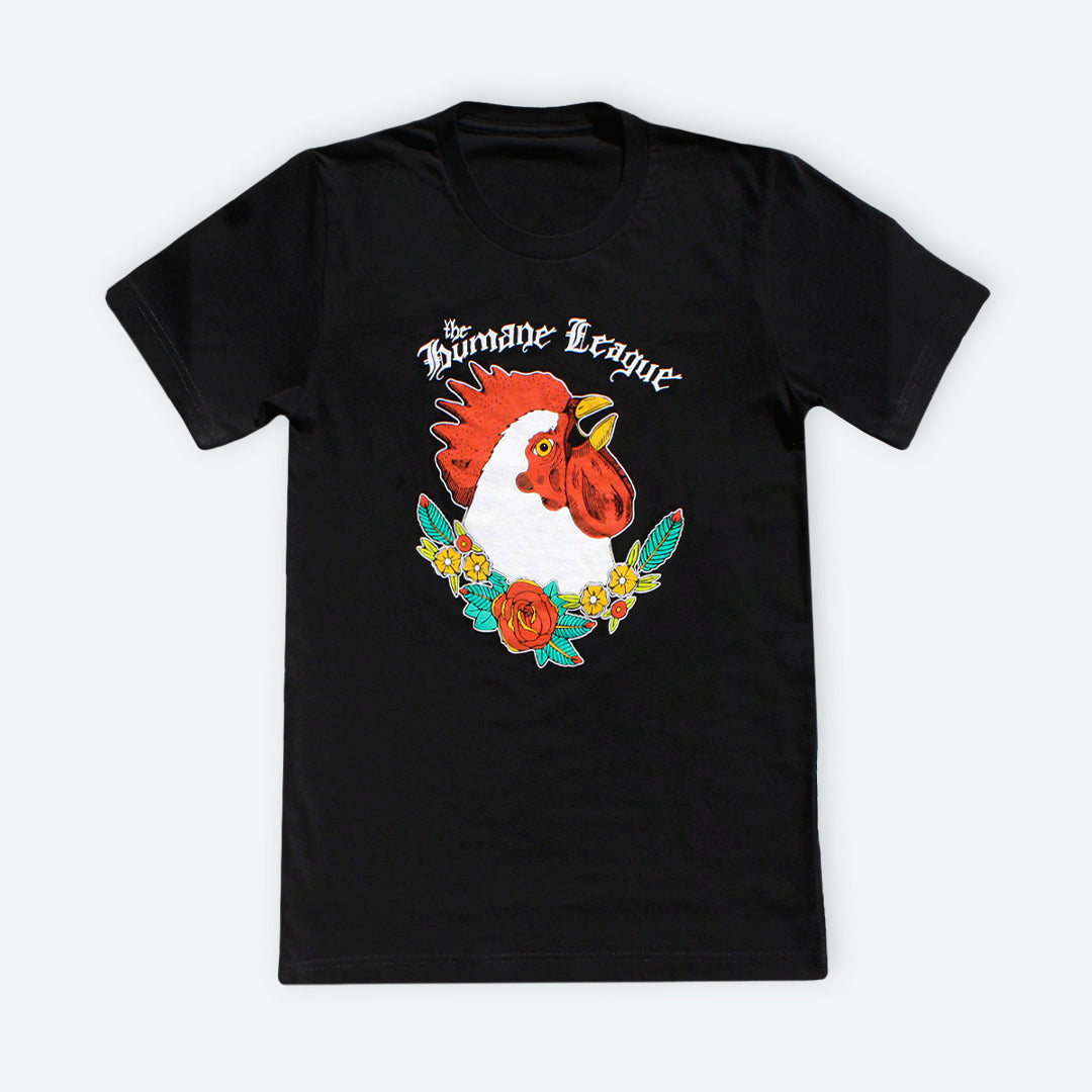 Black short sleeve t-shirt with large chicken design on the front. The Humane League is written in a hand-drawn script above the chicken. The chicken is shown from the neck up and is boldly looking upward. Red roses, yellow flowers, and green leaves weave together underneath the chicken image.