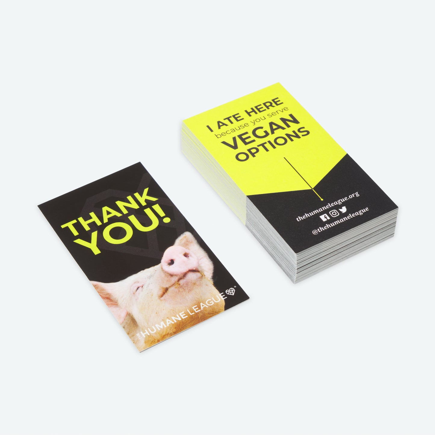 Small stack of business card sized cards. The front of the cards say, "Thank You!" with a photo of the pig. On the back of the cards it says, "I ate here because you serve vegan options".